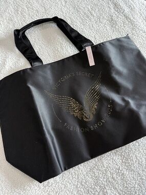 Victoria's Secret Fashion Show 2025 Black Tote with Gold Studded Wing Emblem.